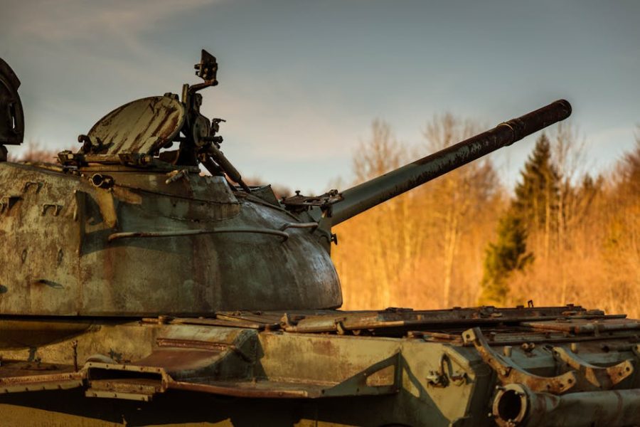 A rusted tank set against a forest background in Bosnia, highlighting historic military remnants.
